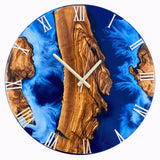 Handmade epoxy resin and olive wood wall clock with vibrant blue resin, brass hands and Roman numerals in a modern living room