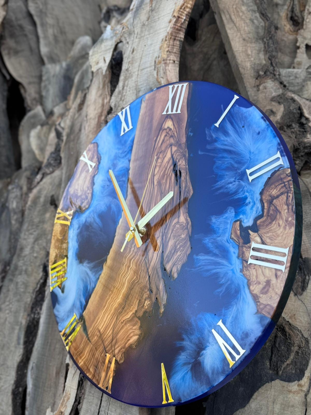 Ocean resin wall clock leaning against a shiplap wall with coastal decor accessories