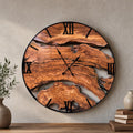 Large handmade olive wood wall clock with live edge rustic design, black Roman numerals and a circular black metal frame, on a textured stone wall