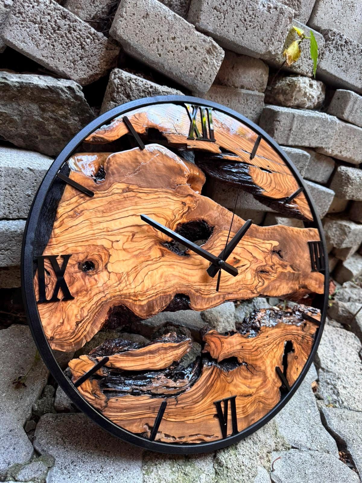 Handmade oversized olive wood wall clock showing rich swirling grain texture and organic live edge silhouette