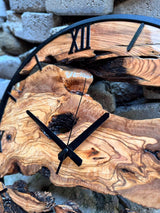 Handmade large olive wood wall clock styled on a gallery wall with neutral linen tones