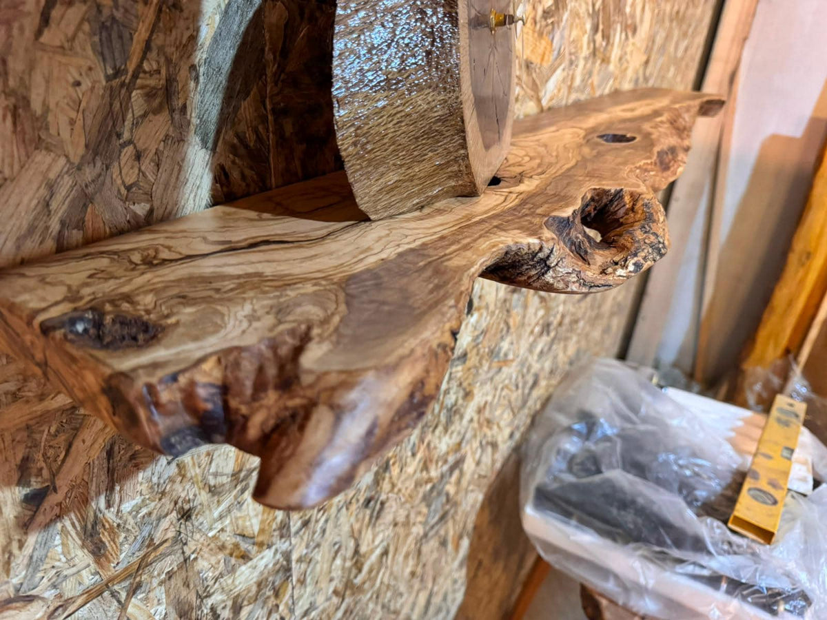 Two olive wood shelves stacked on a wall