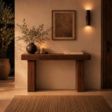 Rustic console table in an entryway with mirror, basket and lamp