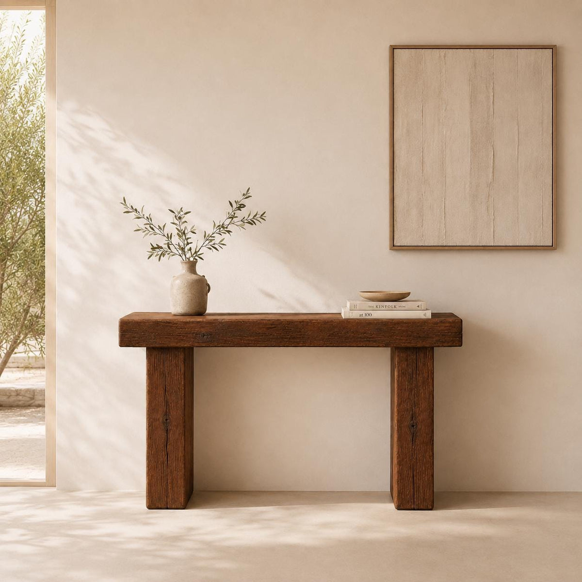 Narrow reclaimed wood hallway table styled with a vase and books against a white wall
