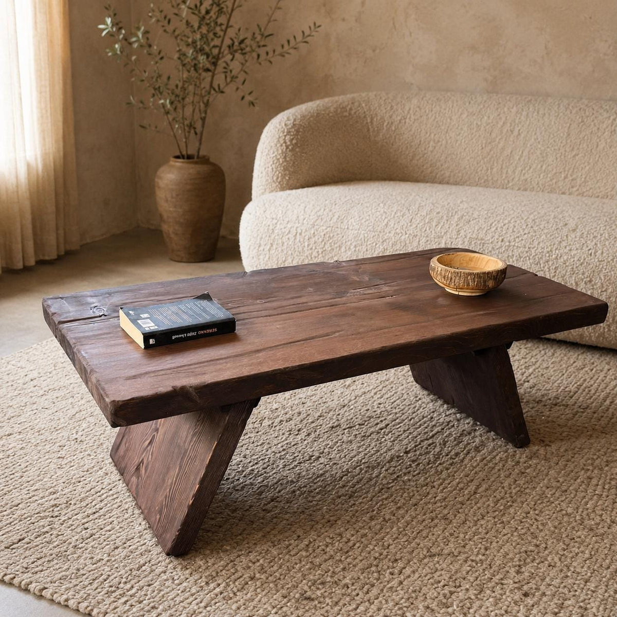 Rustic cedar coffee table styled with a book and wooden bowl in a neutral wabi-sabi living room