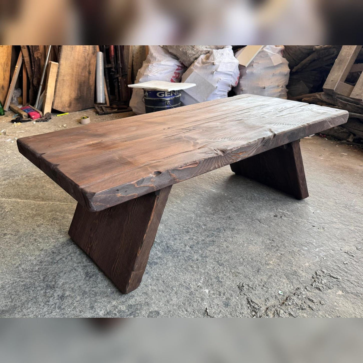 Workshop photo of the handmade cedar coffee table showing its live edge, thick top and solid slab legs