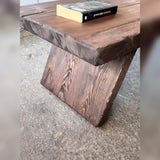 Close-up of the tabletop thickness, rounded corner and wood grain above the slab leg