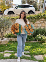 Handmade olive wood epoxy wall clocks in emerald green and turquoise resin, held outdoors for scale