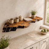 Natural olive wood floating shelf with live edge, mounted on a wall