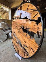 Side-angle view of the extra large live edge olive wood wall clock showing its organic slab pattern