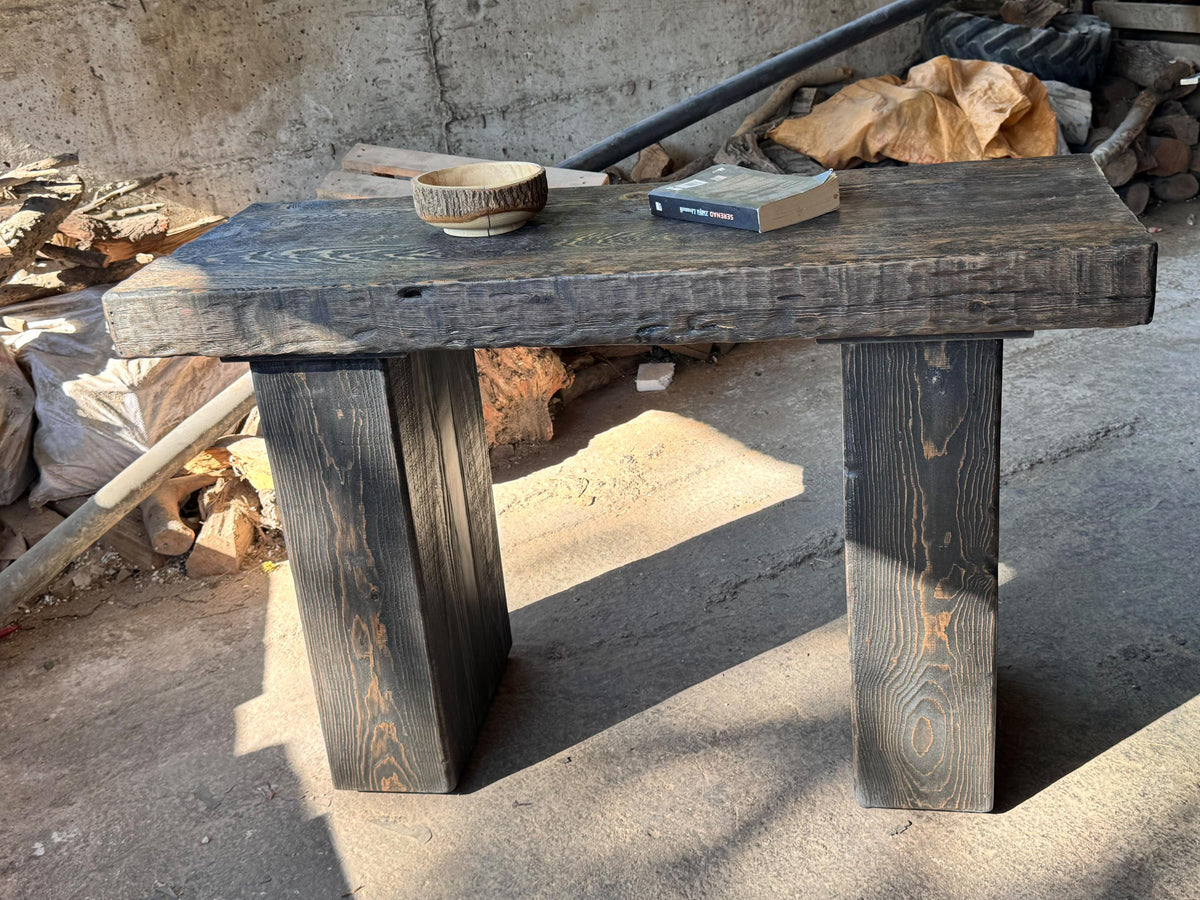 Rustic solid wood entryway table at an angle, showing top depth and leg proportions