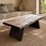 Handcrafted low cedar coffee table with natural grain and slab legs in an organic modern living room