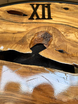 Detail near Roman numeral XII showing rich grain, a natural wood void and the handmade finish