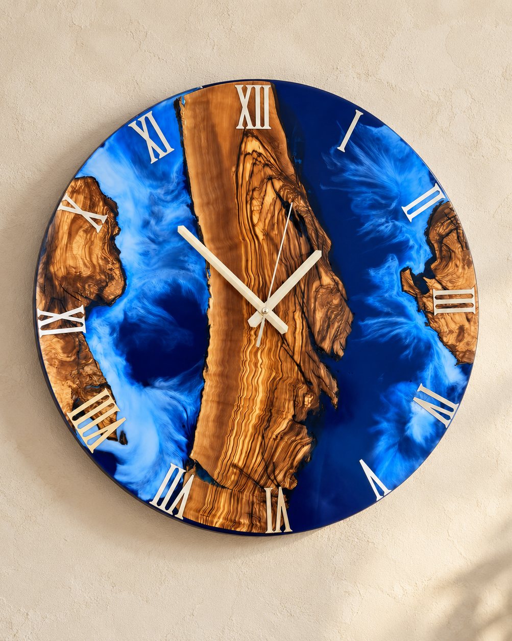 The finished Ocean wall clock in olive wood and cobalt epoxy on a limewashed wall